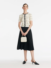 a lady in a striped knit top and black midi skirt two-piece set